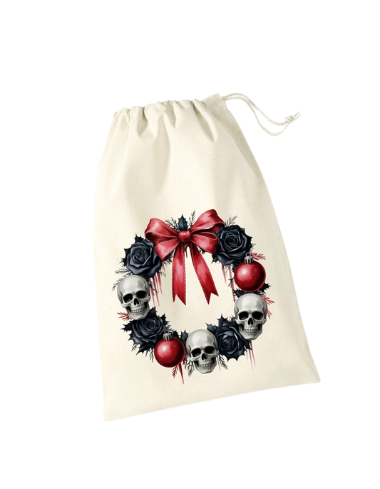 beiges Geschenksackerl aus Baumwolle mit Zugkordel mit Totenkopfkranz, schwarzen Rosen und roter Schleife und roten Kugeln