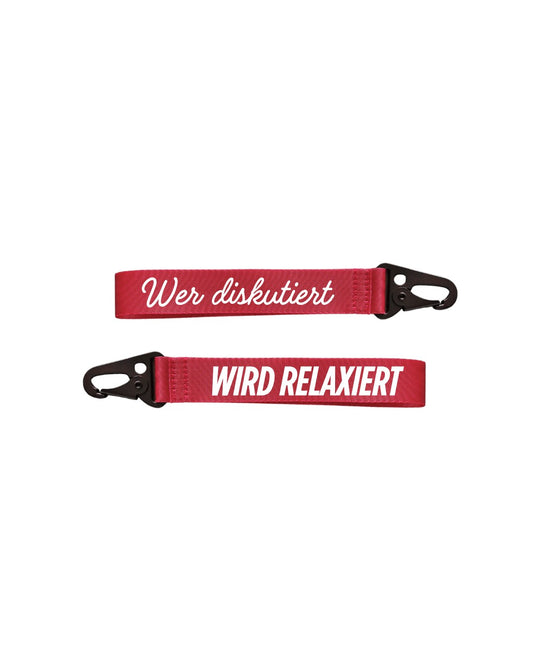 roter schlüsselanhänger aus gurtband mit weißer schrift "wer diskutiert" andere seite "wird relaxiert"